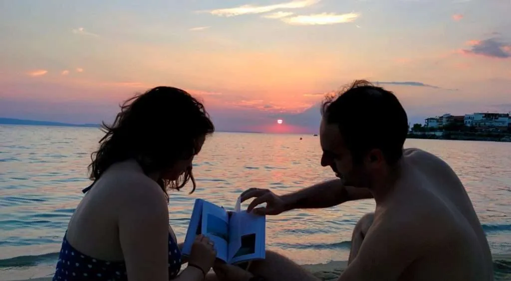 travelers reading on the beach - Greece, Chalkidiki, Neos Marmaras, Follow the locals book