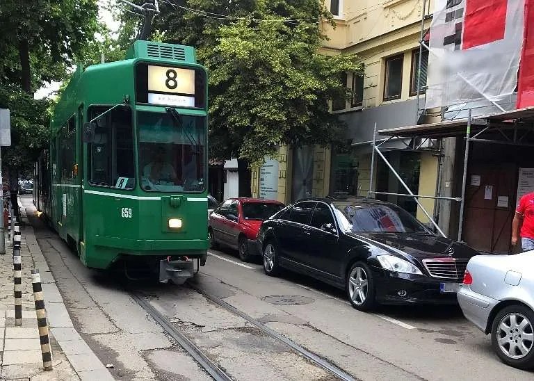 A guide to Sofia, Bulgaria by locals - tram and parked cars on a tiny street