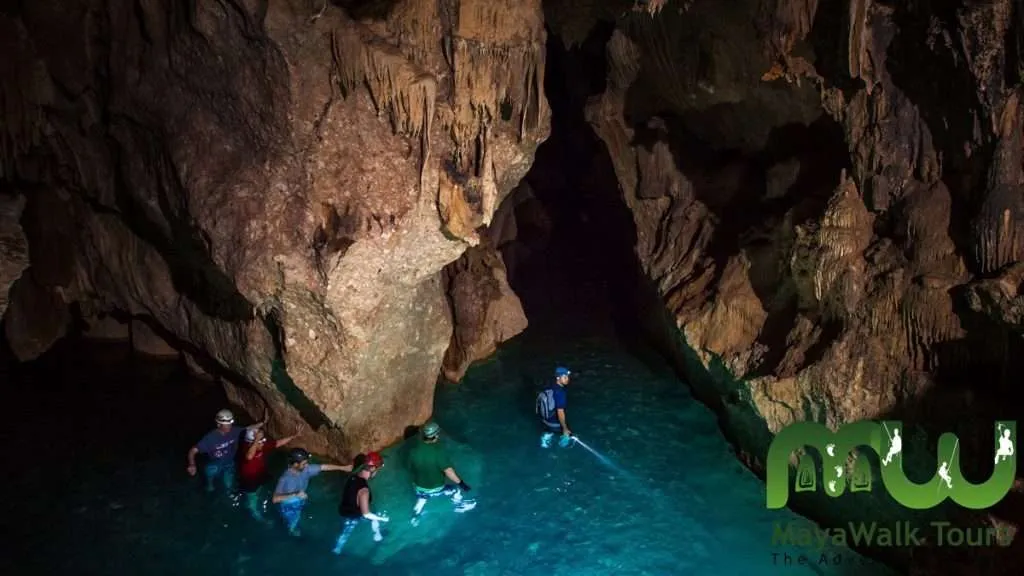 Tourist walking in the water at the ATM cave in Belize