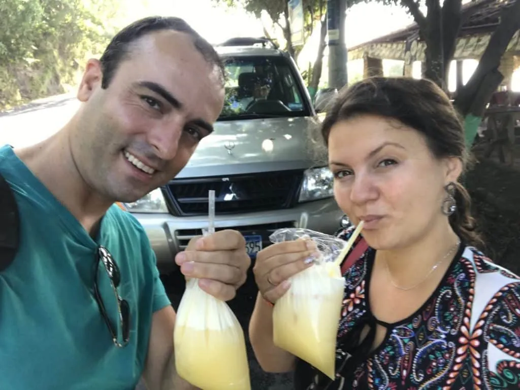Drinking fresh orange juice served in plastic bags with straw in El Salvador