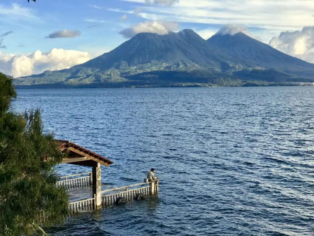 One man is fishing on the edge of an almost sunk platform at the lake Atitlan, San Marcos la Laguna village in Guatemala