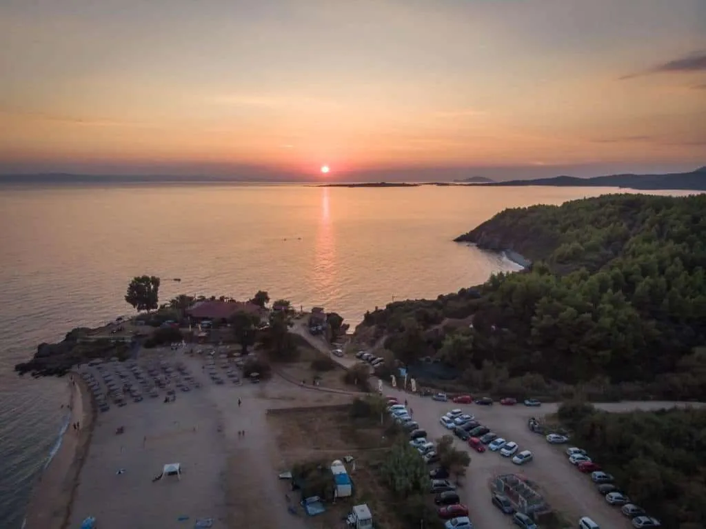 Drone photo of the sunset over the Ethnik Bar and the Tristenika Beach in Greece