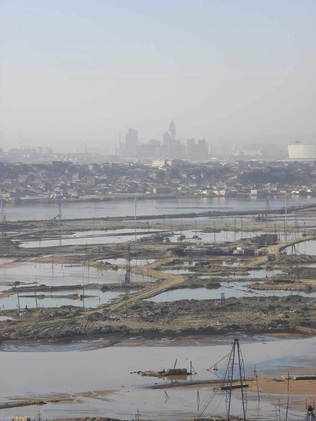 Polluted land behind the skyscrapers of Baku, by Johannes Plate